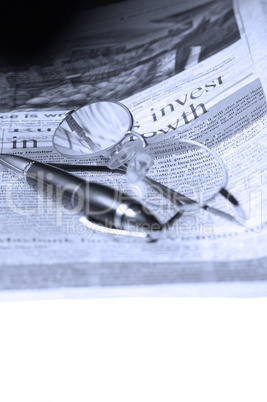 pen and glasses and newspaper