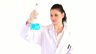 Laborarbeiterin im Kittel hält ein Reagenzflasche