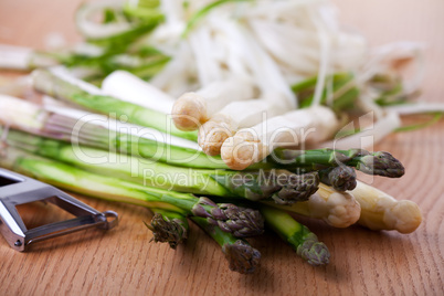 Roher weißer und grüner Spargel auf einem Tisch aus Eichenholz