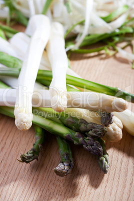 Roher weißer und grüner Spargel auf einem Tisch aus Eichenholz