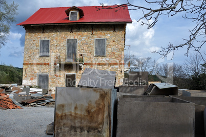 derelict stone house and pile of box crates