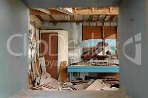 ramshackled room with boarded up window