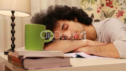 young man falling on a sleep while studying