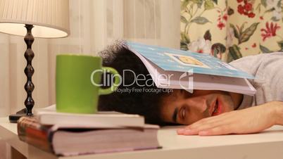 young man falling on a sleep while studying