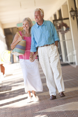 Happy Senior Couple Holding Hands in Shopping Mall