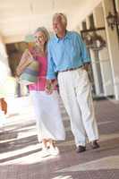 Happy Senior Couple Holding Hands in Shopping Mall