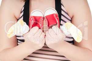 Portrait of pretty pregnant woman baby shoes