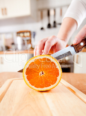 Woman's hands cutting orange