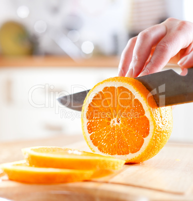 Woman's hands cutting orange