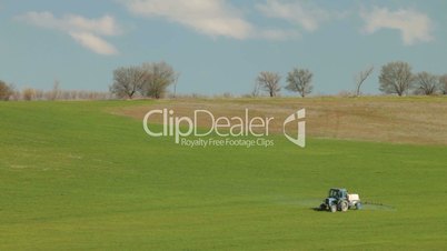 Tractor spraying field in spring