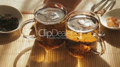 Woman mixes brown sugar in glass of tea