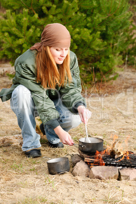 Camping woman cook food fire nature