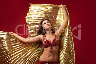 Young girl dance with gold wing on red