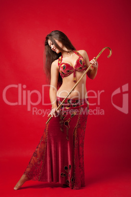 Young woman dance with cane in red arabic costume