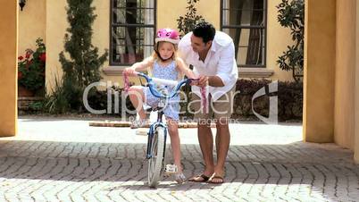 Ethnic Father Teaching Daughter on Bicycle