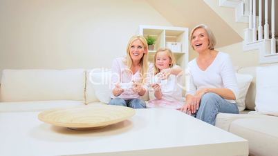 Child Playing on Games Console with Family