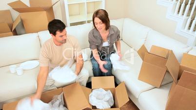 Couple Having Fun with Moving Home Wrappings