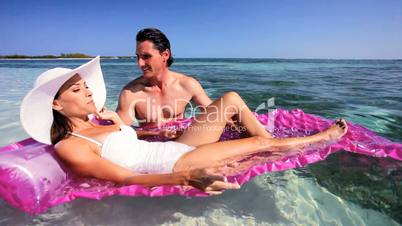 Vacation Couple in Ocean with Air Mattress
