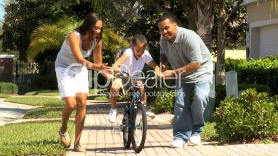Parents Teaching Son to Ride Bicycle