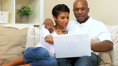 Young Ethnic Couple Using Laptop at Home