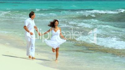 Couple Running Along Tropical Beach
