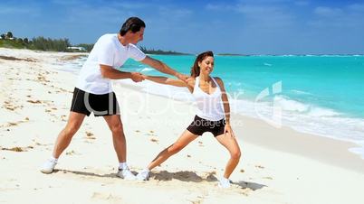 Young Couple in Sportswear Exercising on Beach