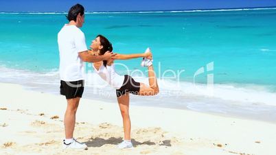 Healthy Couple Doing Muscle Stretches on Beach