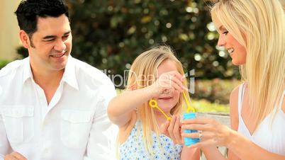 Multi-Ethnic Family Fun Blowing Soap Bubbles