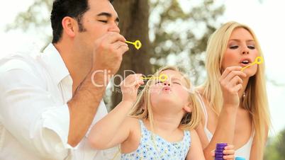 Multi-Ethnic Family in Park with Play Bubbles
