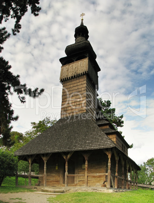 Old wooden church in the background of the cloudy sky