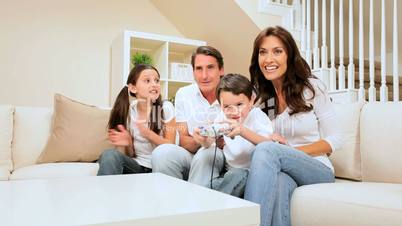 Family Encouraging Son Playing  Games Console