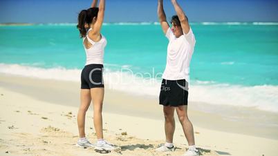 Young Couple in Sportswear Exercising on Beach