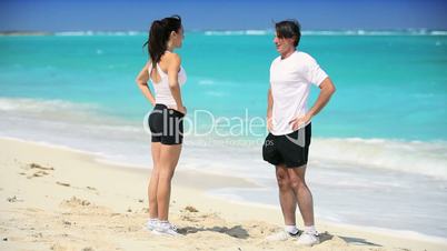 Young Couple in Sportswear Exercising on Beach