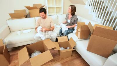 Couple Unpacking House Moving Cartons