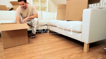 Young Couple Unpacking House Moving Cartons