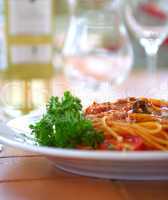Spaghetti with a tomato sauce on a table in cafe