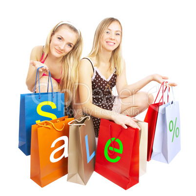 Two girls with bags - comparison shopping. Sale!