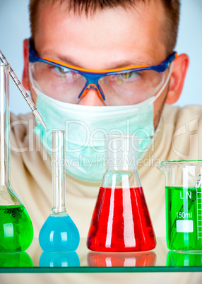 Young scientist in laboratory with test tubes