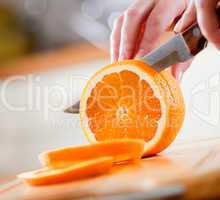 Woman's hands cutting orange