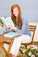 Summer terrace redhead woman relax with book