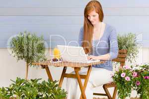 Summer terrace redhead woman with laptop