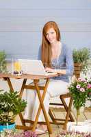Summer terrace redhead woman with laptop