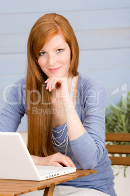 Summer terrace redhead woman with laptop