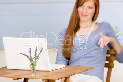 Summer terrace redhead woman with laptop