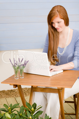 Summer terrace redhead woman with laptop