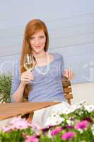 Summer terrace redhead woman hold glass of wine