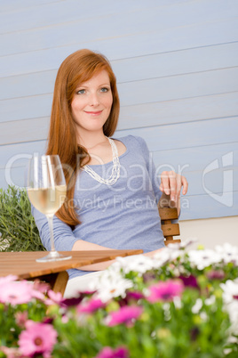 Summer terrace redhead woman with glass of wine