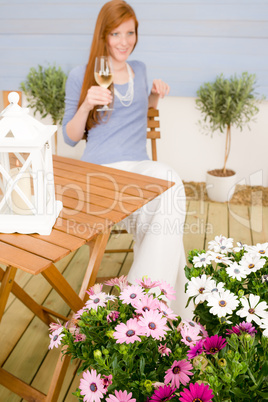 Summer terrace redhead woman hold glass of wine