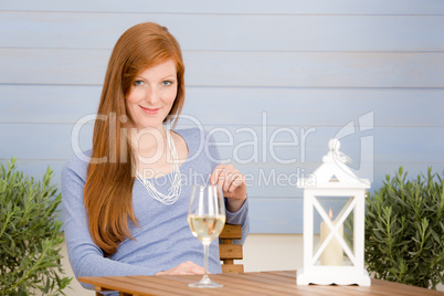 Summer terrace redhead woman with glass of wine