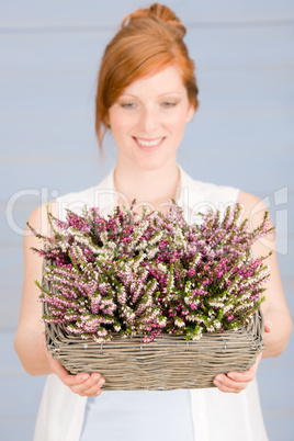 Summer redhead woman hold basket with flowers